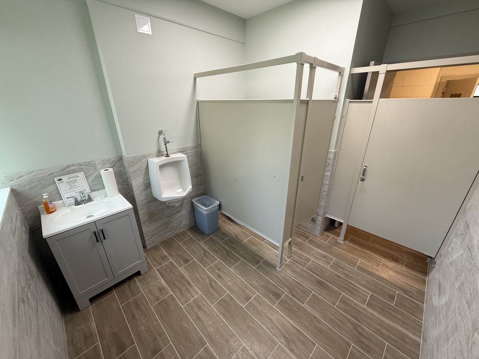 Finished commercial restroom renovation with new tile and vanity