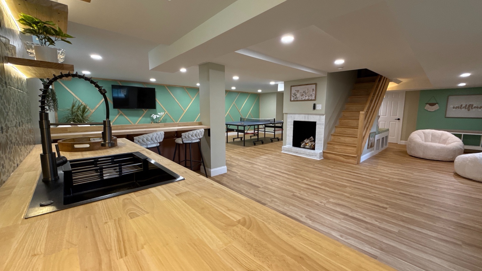 Finished basement renovation with bar, fireplace, and recreation area